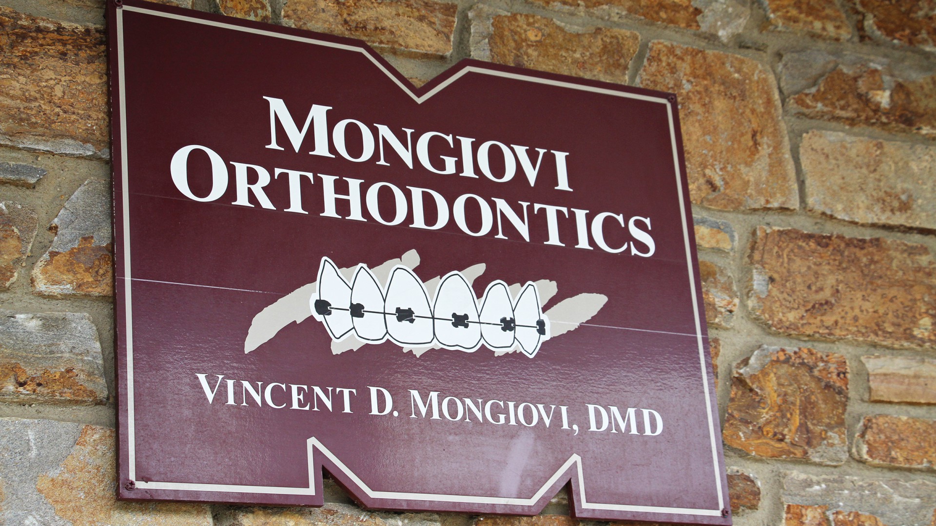 Picture of the Mongiovi Orthodontics sign on the front of the building