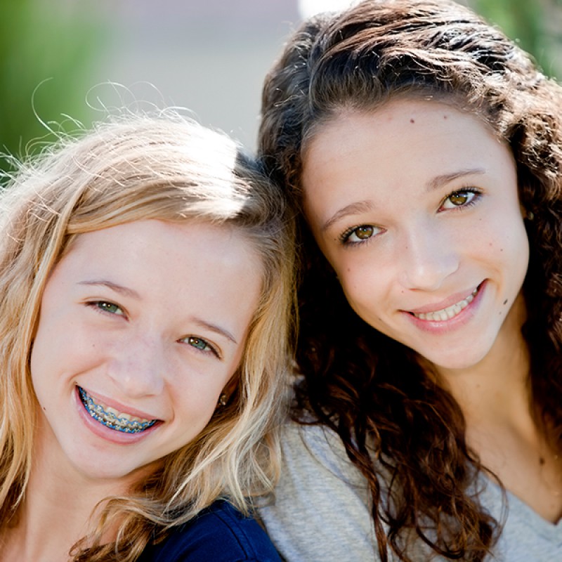 Picture of two young girls, one with braces, both smiling